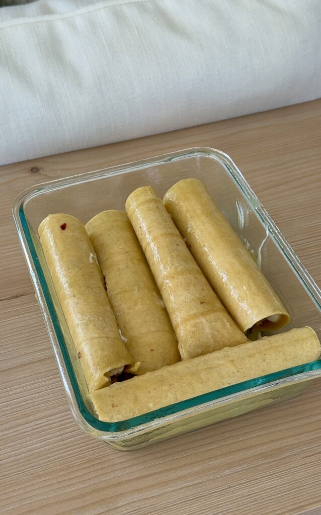 Chicken Enchiladas: Roll the tortillas, top with additional enchilada sauce, and bake